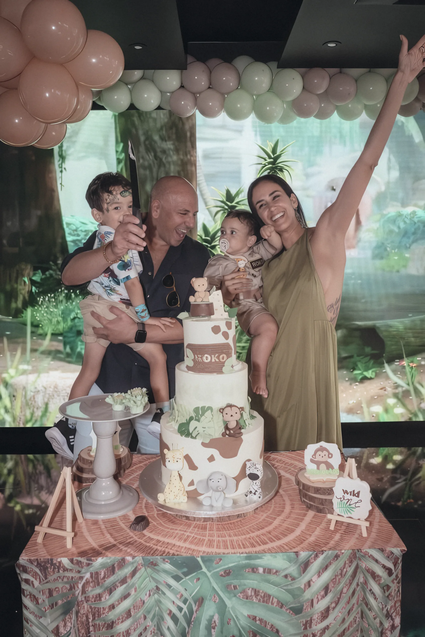 Maria celebrating with her family around a safari birthday cake